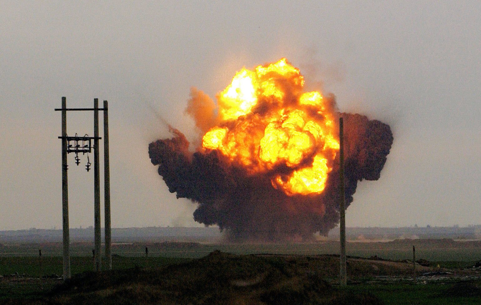 Explosions rock Al Fathah Air Field in Iraq, as Army engineers and Air Force EOD personnel work together to detonate a weapons cache. An estimated two-million net pounds of explosives were left at the air field by the old regime, making Al Fathah the largest single weapons cache uncovered by the coalition, and they are destroying it at an average of 100,000 pounds per day. (Photo by USAF Staff Sgt. Jeffrey A. Wolfe) RELEASED